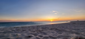 Sunset over a wide white-sand beach on Aruba's west coast